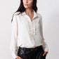 Off-white blouse with pointed collar, button front, long sleeves and textured placket