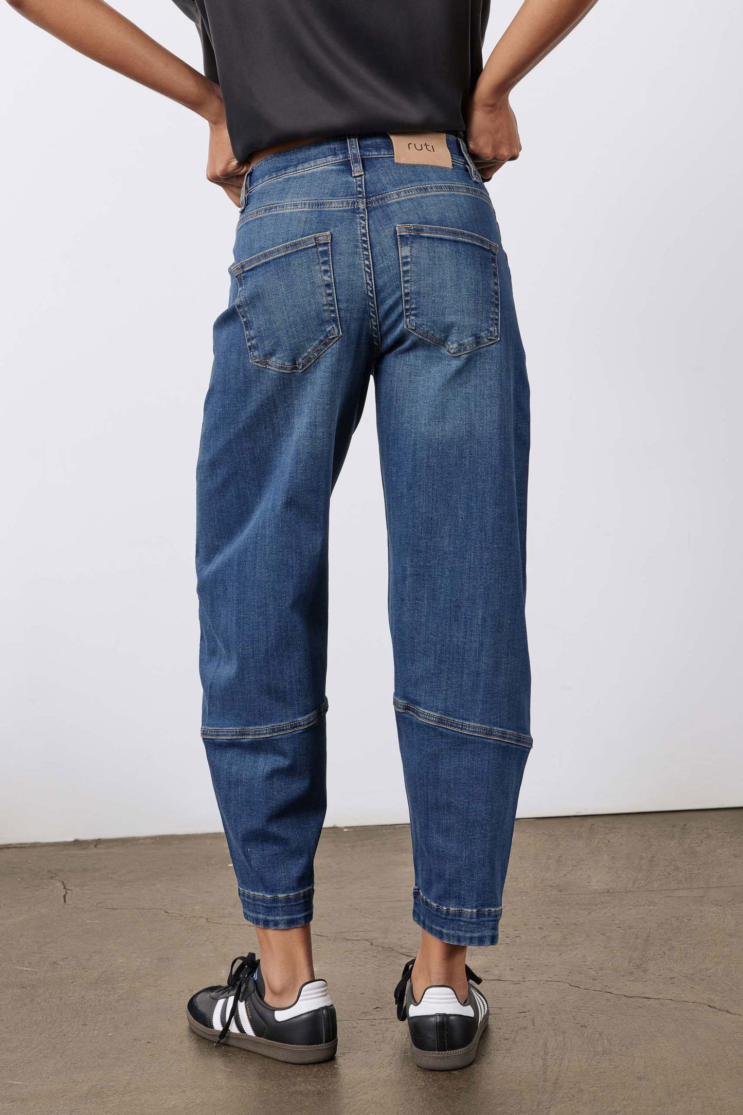 Indigo denim jeans with back yoke, patch pockets, and rolled cuffs