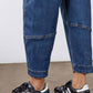 Indigo jeans leg close-up with contrast-stitched cuffs and rolled hem