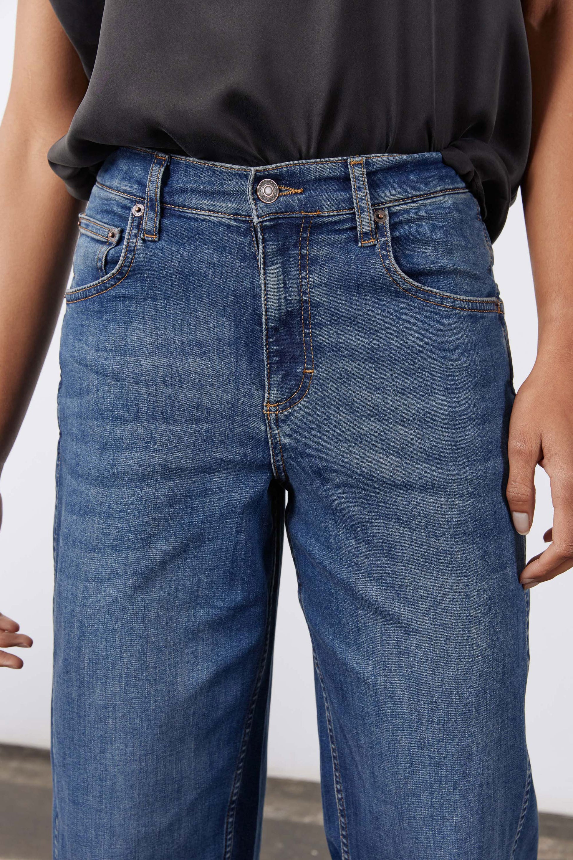 Indigo denim jeans waistband with button closure and belt loops