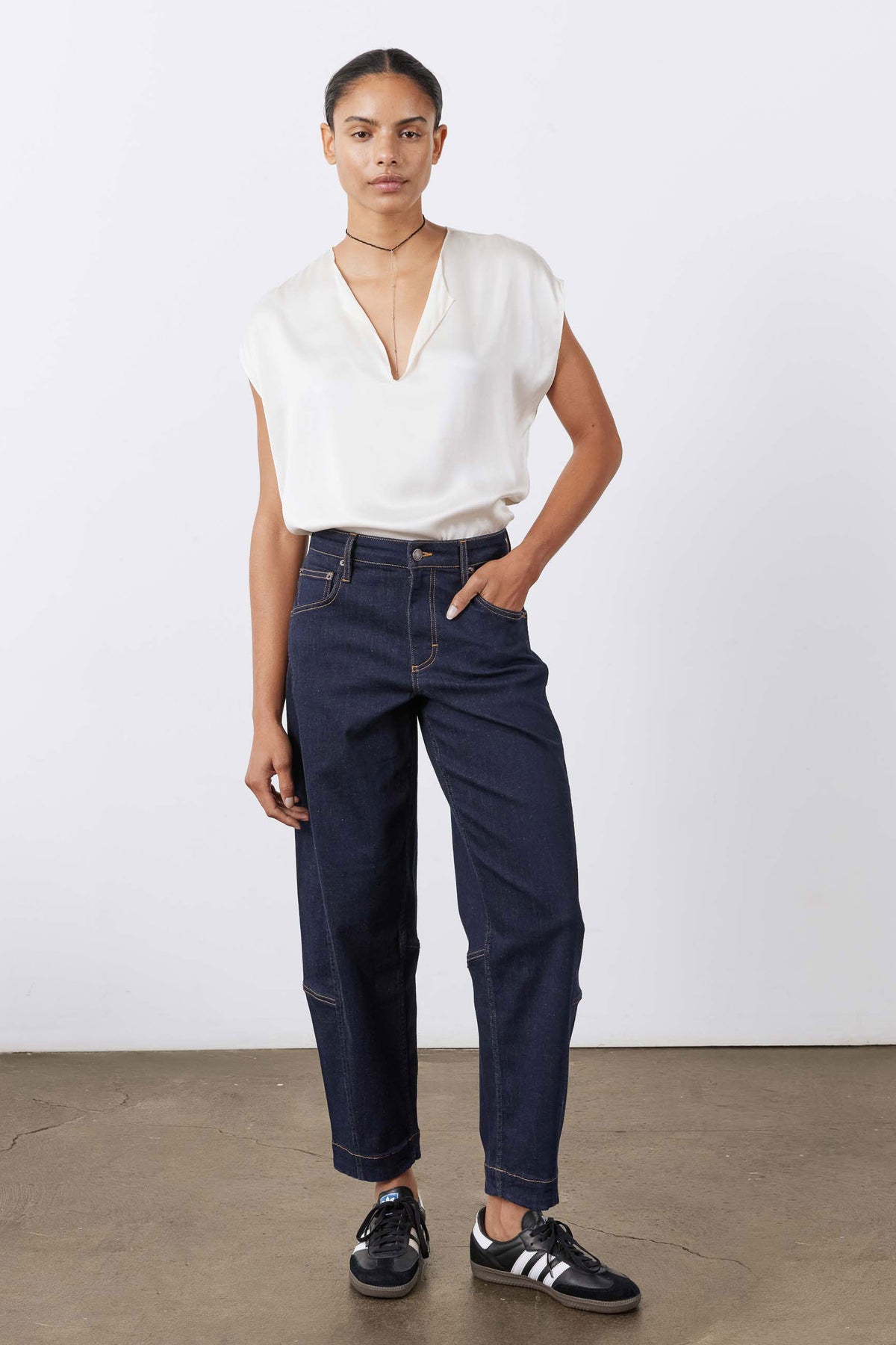 Dark wash barrel-leg jeans with cuffed hem, belt loops, and zipper fly