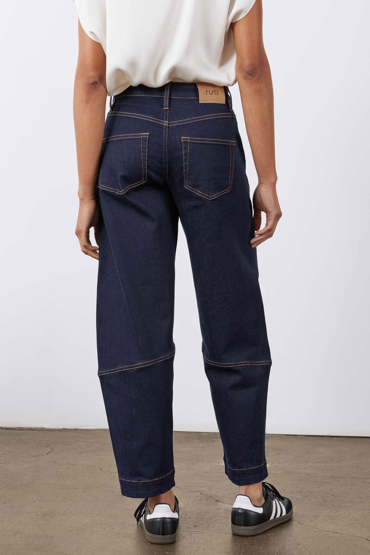 Dark wash barrel-leg jeans with front patch pockets and contrast stitch lines