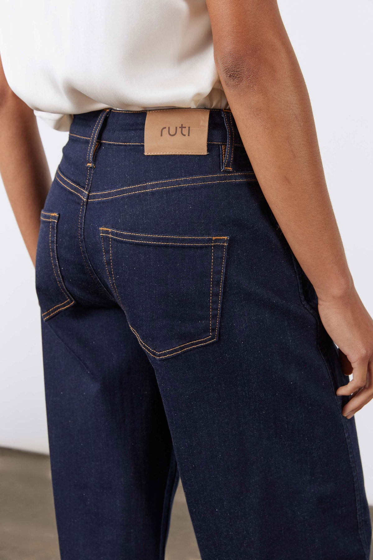 Dark wash barrel-leg jeans with leather waistband brand label and belt loops