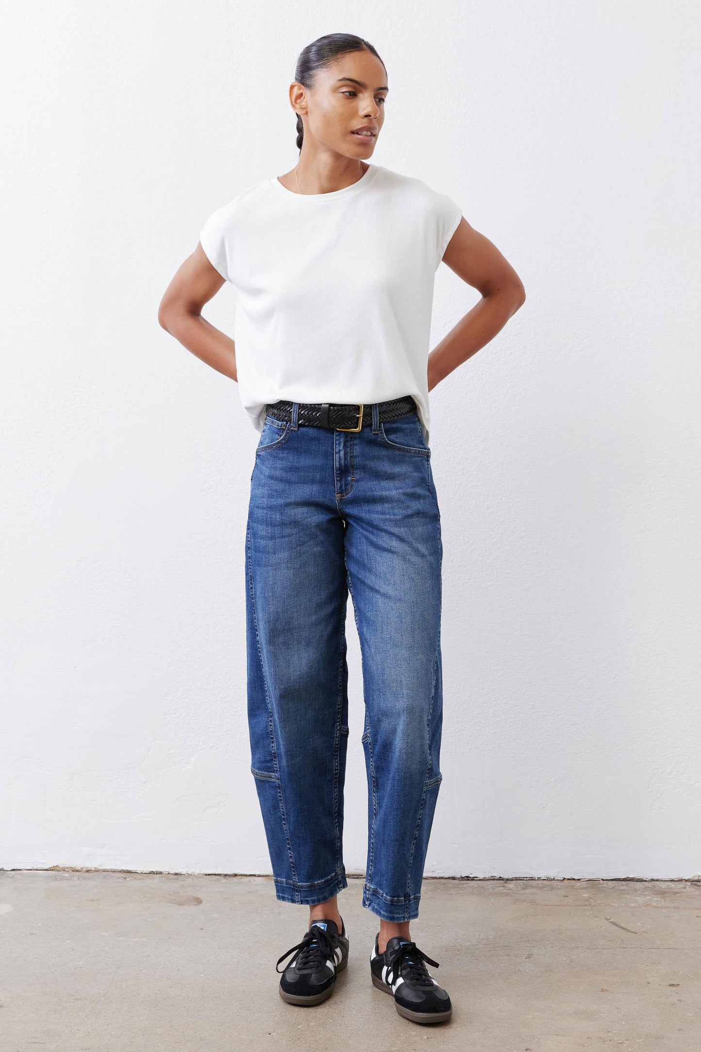 Indigo barrel-leg jeans with mid-rise fit, belt loops, and button-front closure