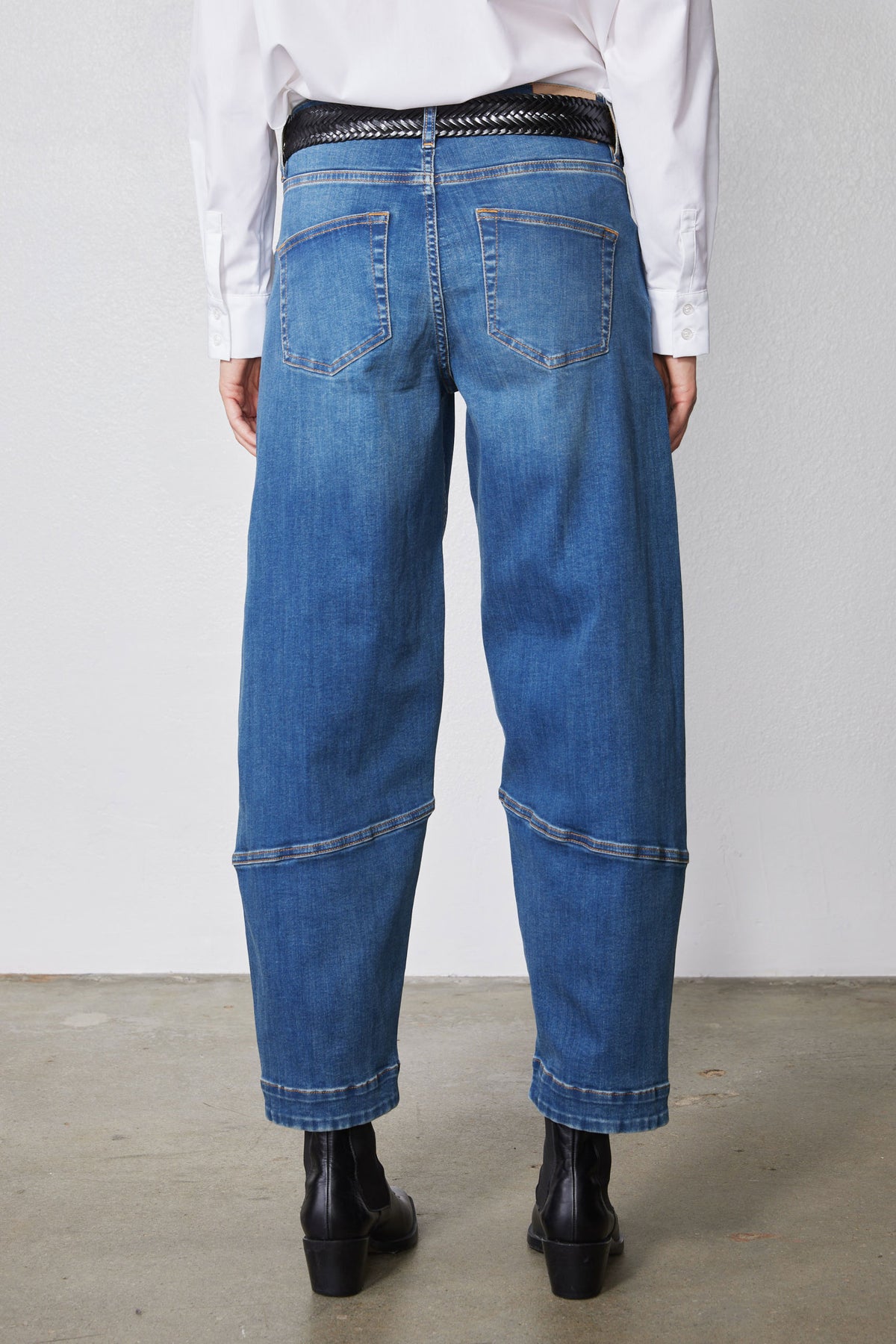 Indigo barrel-leg jeans rear view with yoke seam details and cuffed hems