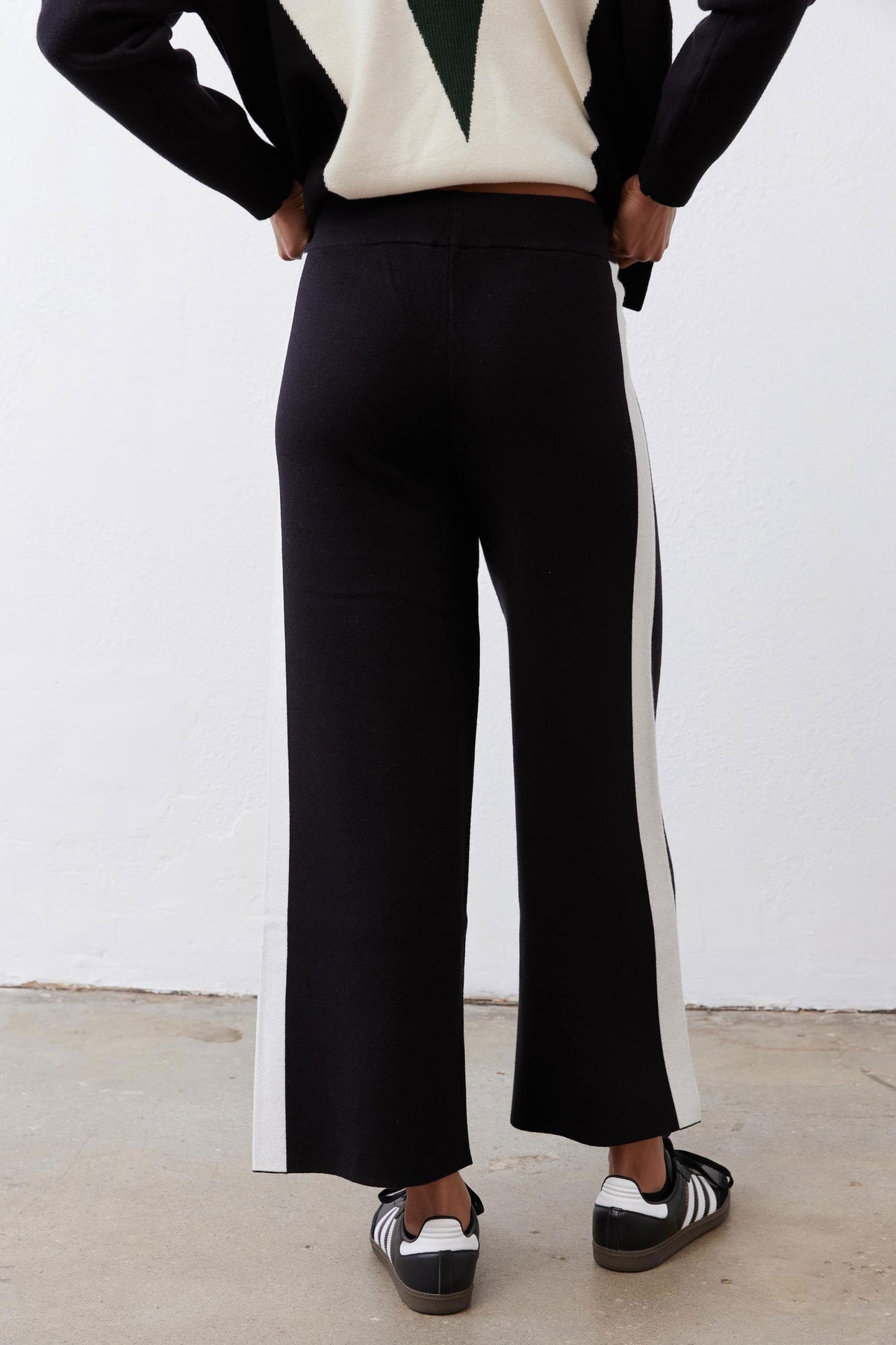 Black lounge pants with vertical ivory stripe and wide-leg hem