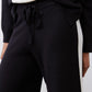 Black lounge pants with drawstring waist and ivory side stripe panel detail