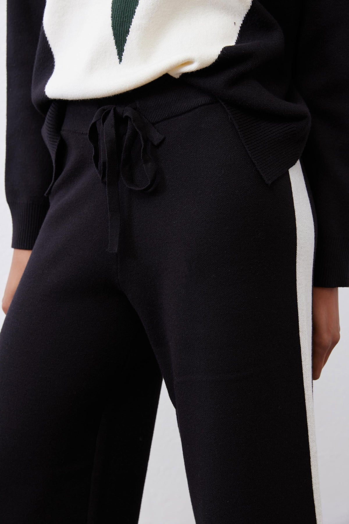 Black lounge pants with drawstring waist and ivory side stripe panel detail