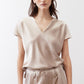 Champagne V-neck short-sleeve top with subtle sheen and relaxed drape