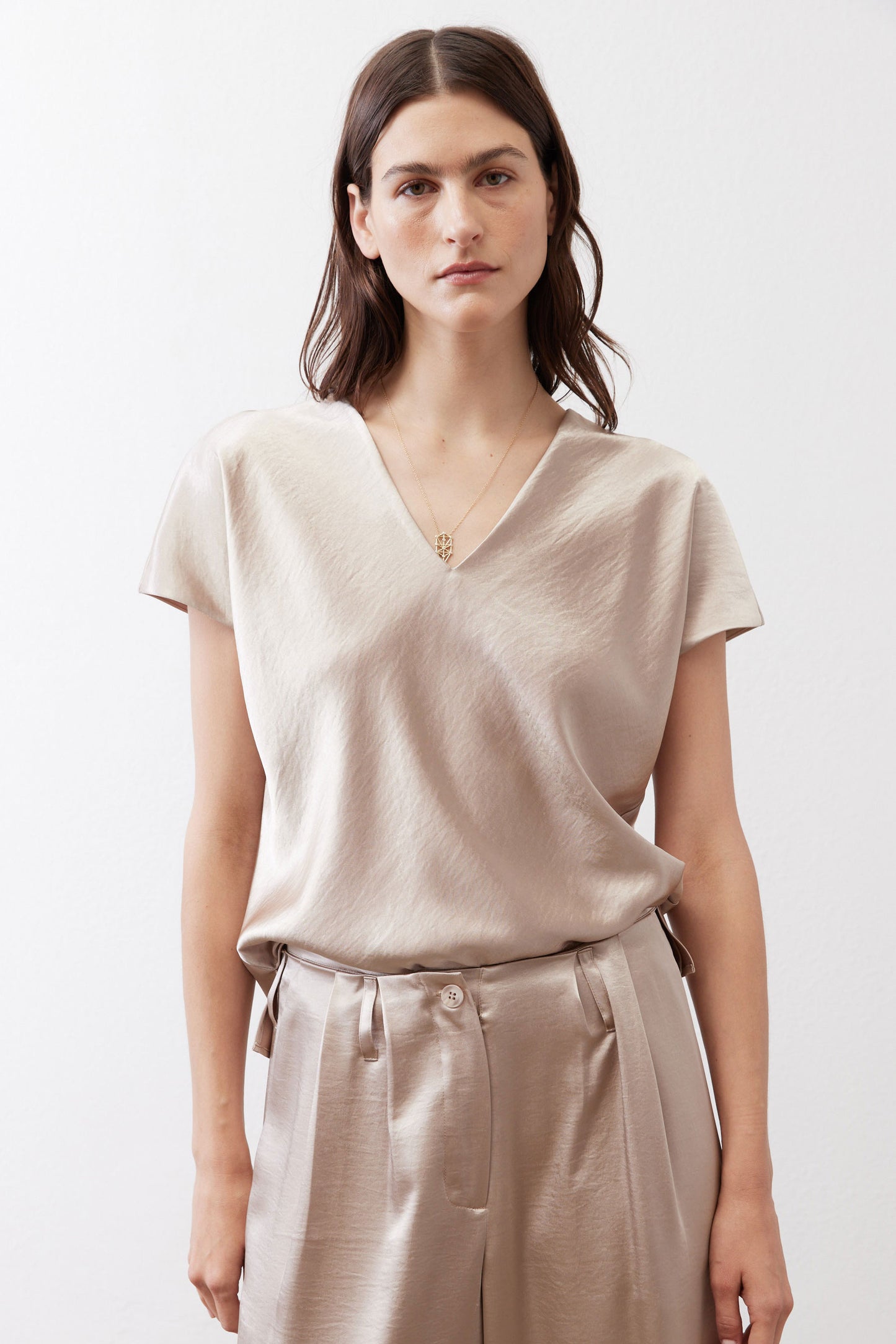 Champagne V-neck short-sleeve top with subtle sheen and relaxed drape