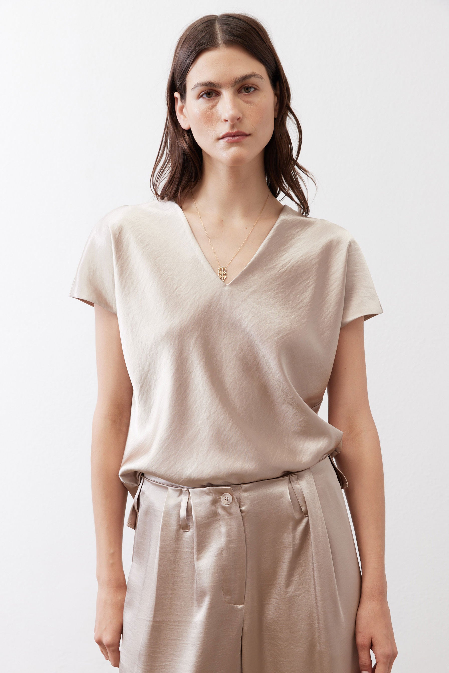 Champagne V-neck short-sleeve top with subtle sheen and relaxed drape