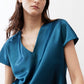 Deep teal V-neck short-sleeve top with soft drape and sheen