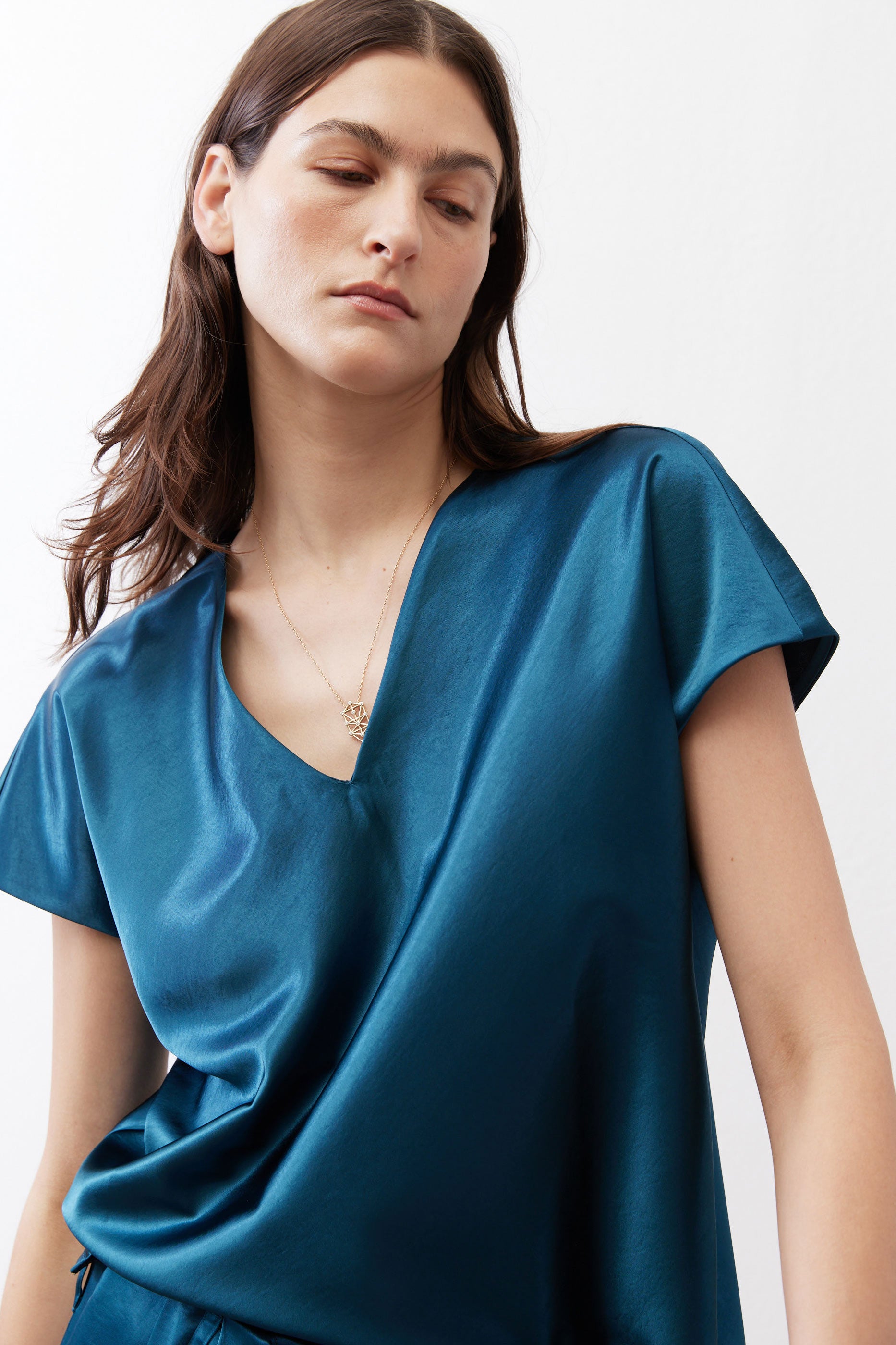 Deep teal V-neck short-sleeve top with soft drape and sheen