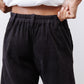 Black corduroy pants with elastic waistband and relaxed pleated front