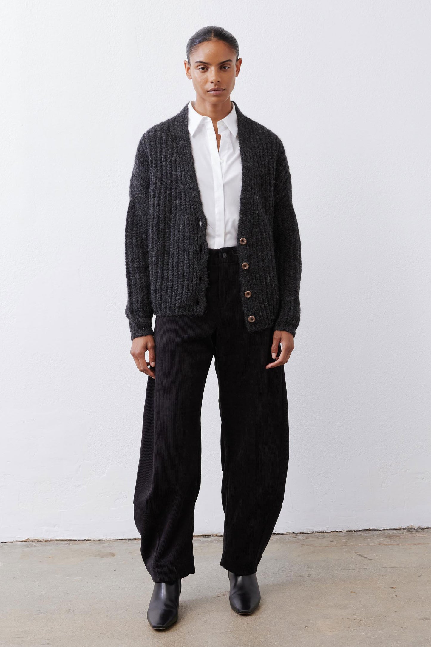 Black corduroy barrel pants with gathered waist and relaxed wide-leg silhouette