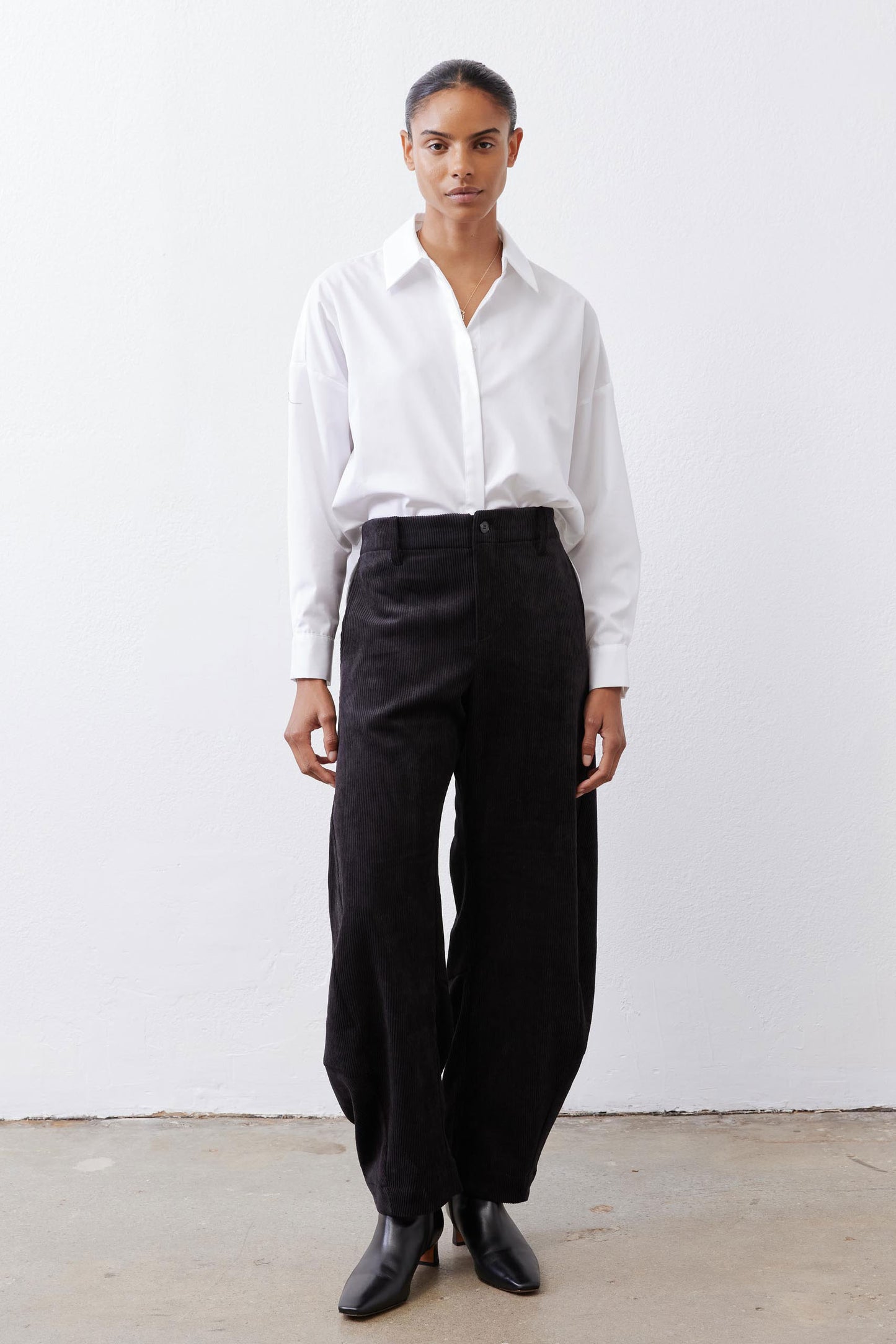 Black corduroy pants with high-rise waistband and loose barrel-leg cut