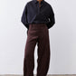 Chocolate-plum corduroy barrel pants on model, relaxed straight legs with pockets