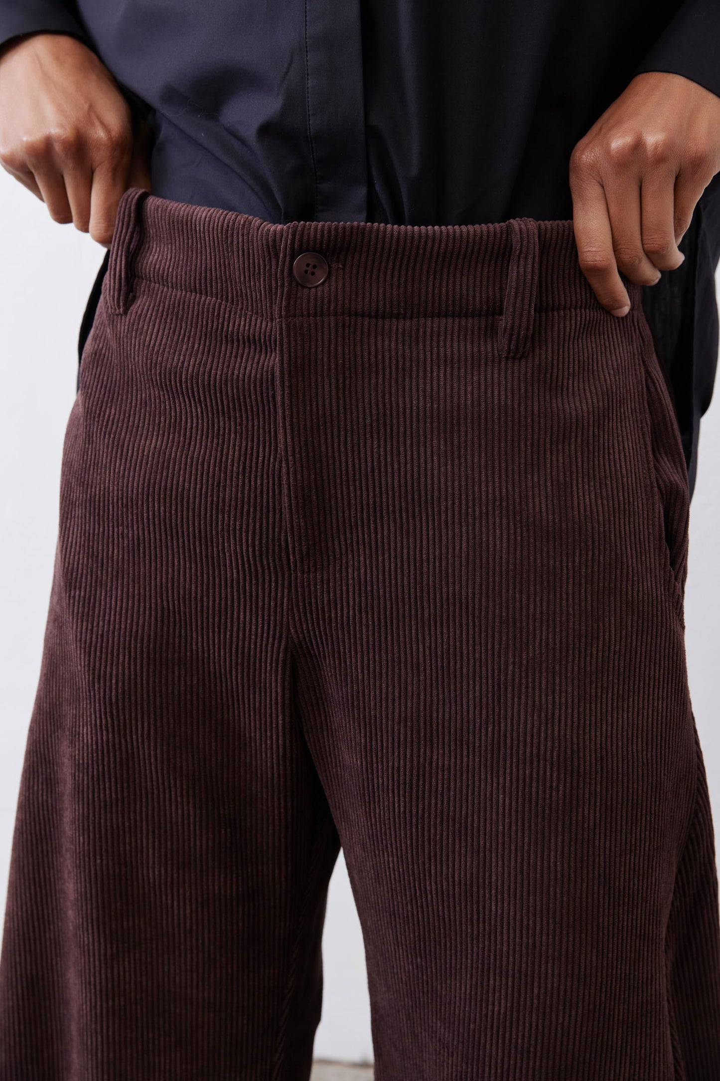 Chocolate-plum corduroy barrel pants close-up, button fly and welt pockets