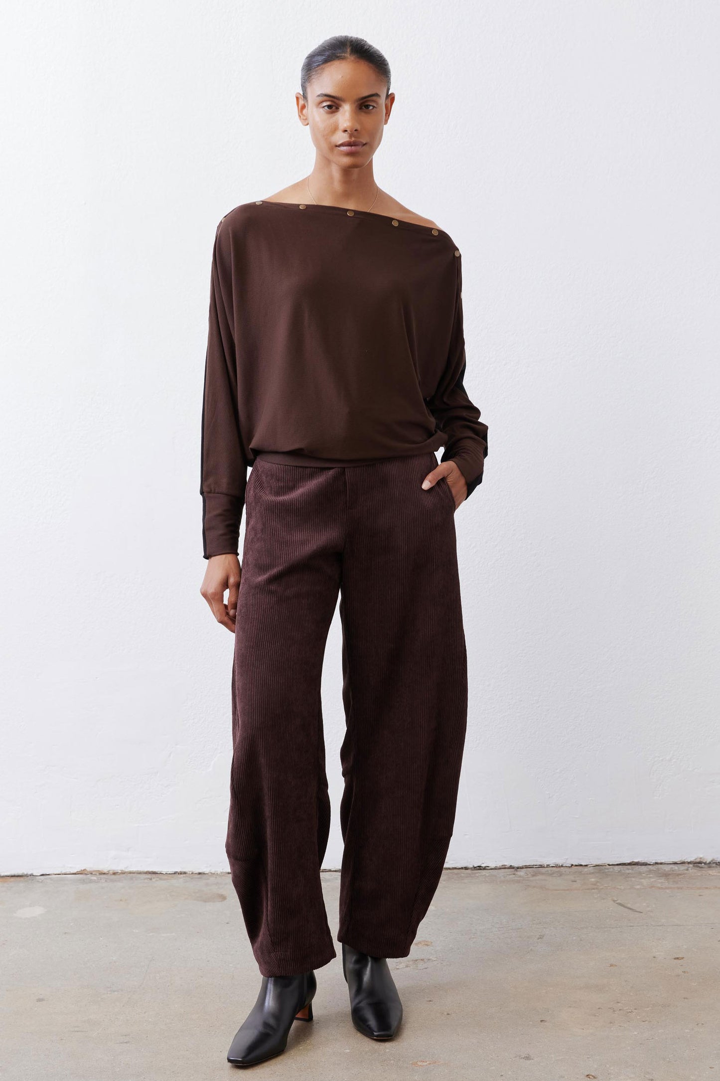 Chocolate-plum corduroy barrel pants on model, loose fit with cropped-ankle hem