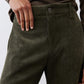Dark green corduroy barrel pants close-up: buttoned waistband and textured fabric