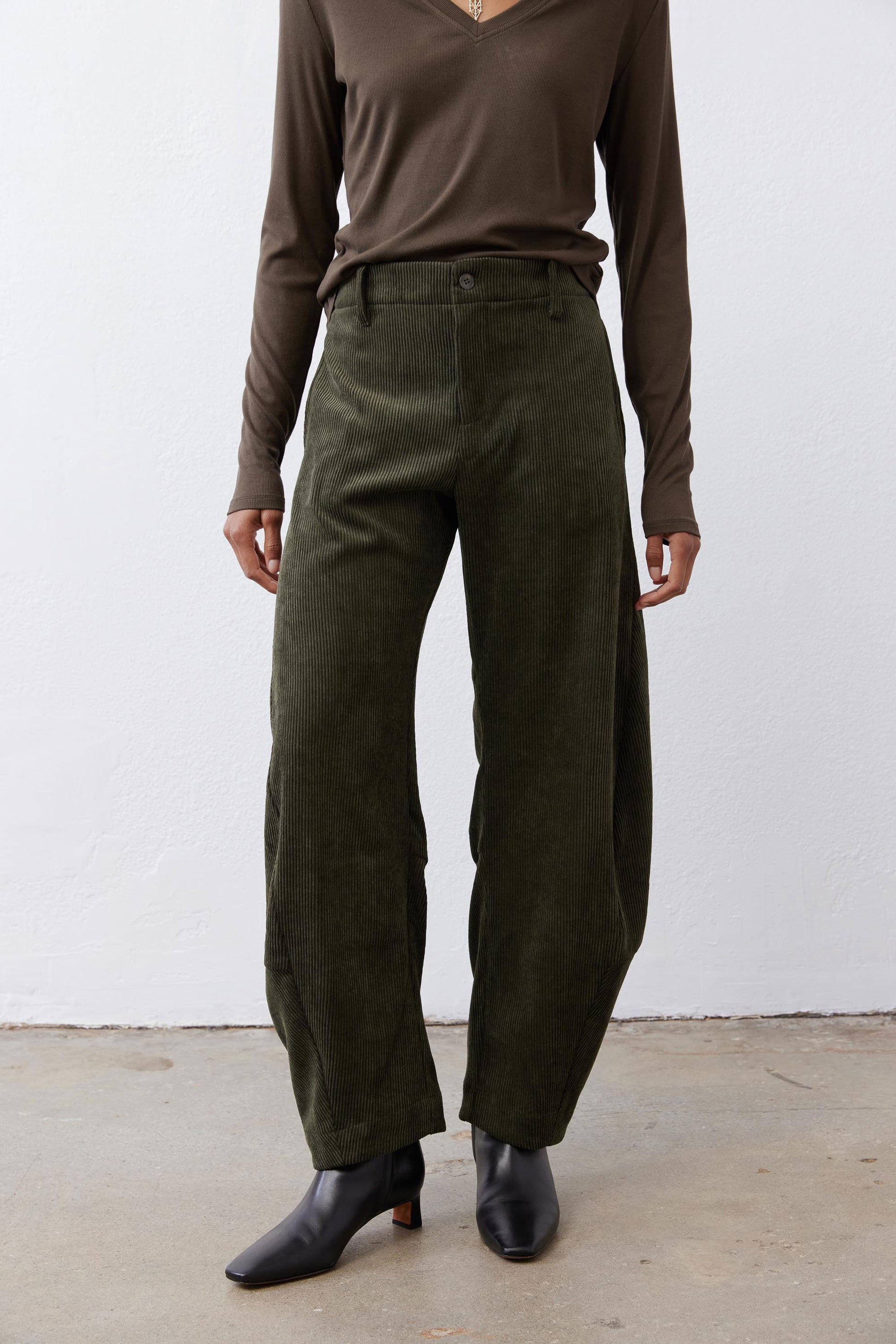 Dark green corduroy barrel pants with wide legs and a mid-rise waistband
