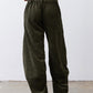 Dark green corduroy barrel pants with elastic waistband and cuffed, roomy ankles