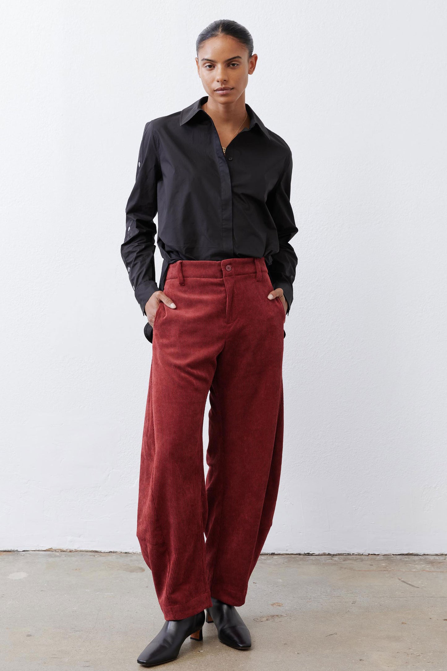 Pomegranate corduroy barrel pants showing button closure and roomy rise