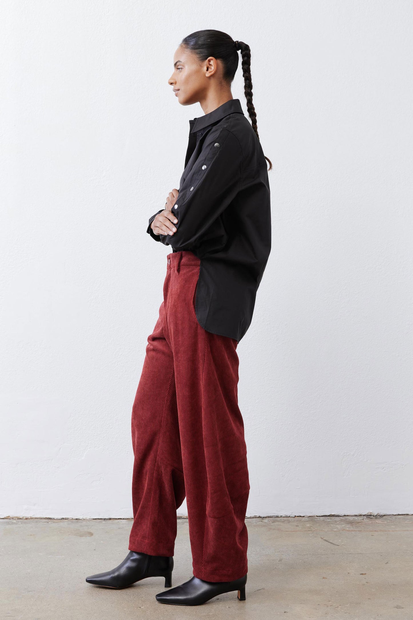 Pomegranate corduroy barrel pants in side profile with full-length relaxed leg