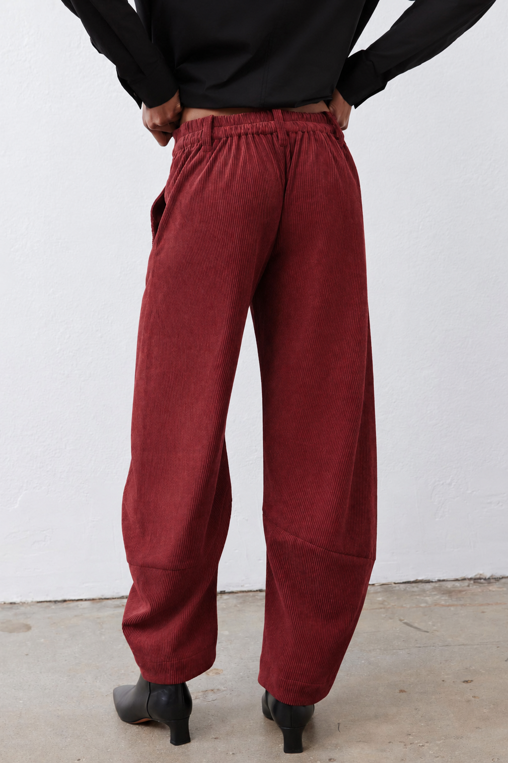 Pomegranate corduroy barrel pants rear view with gathered waistband and relaxed leg