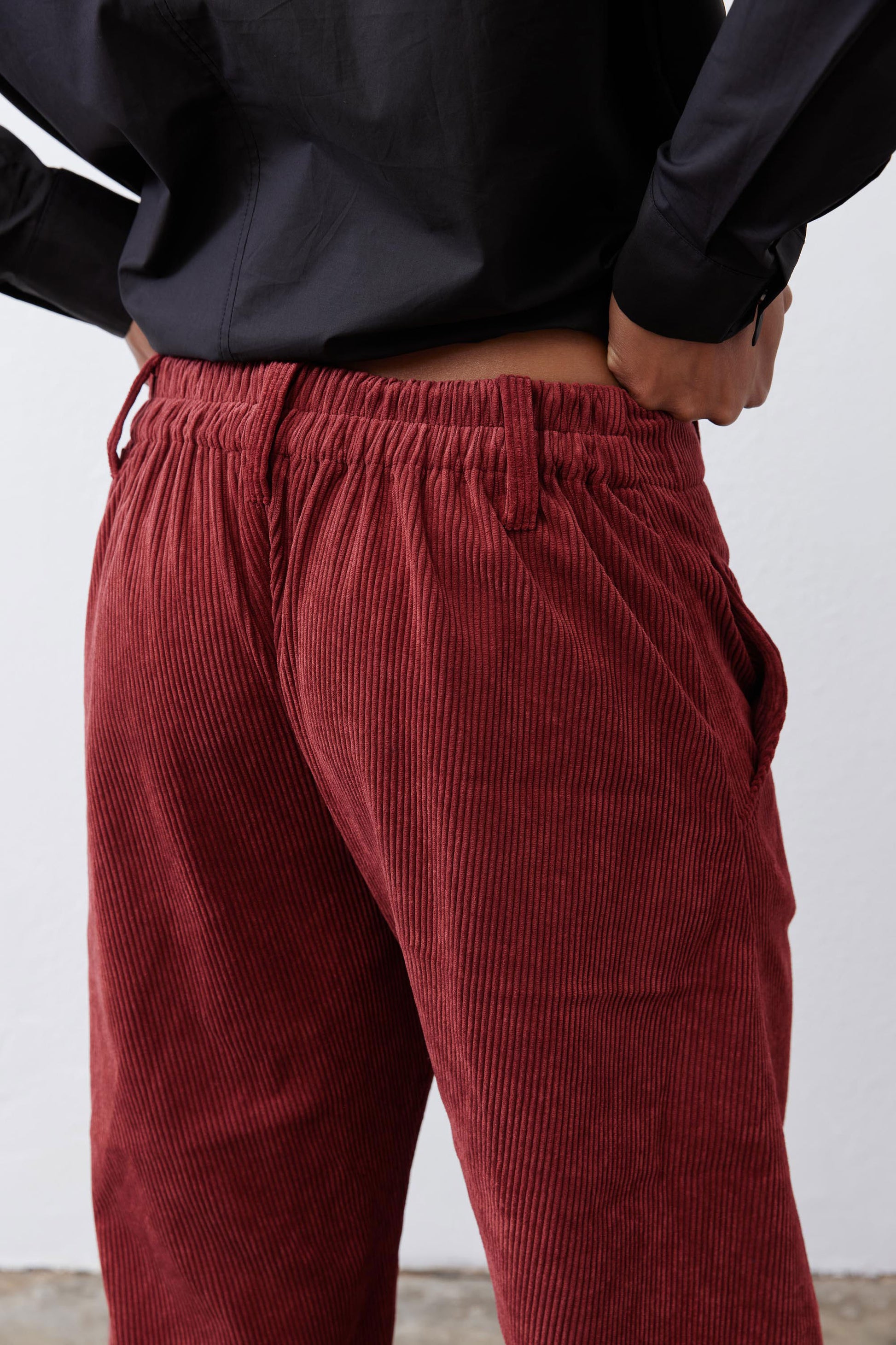 Pomegranate corduroy pants close-up of ruched waistband and vertical cord texture