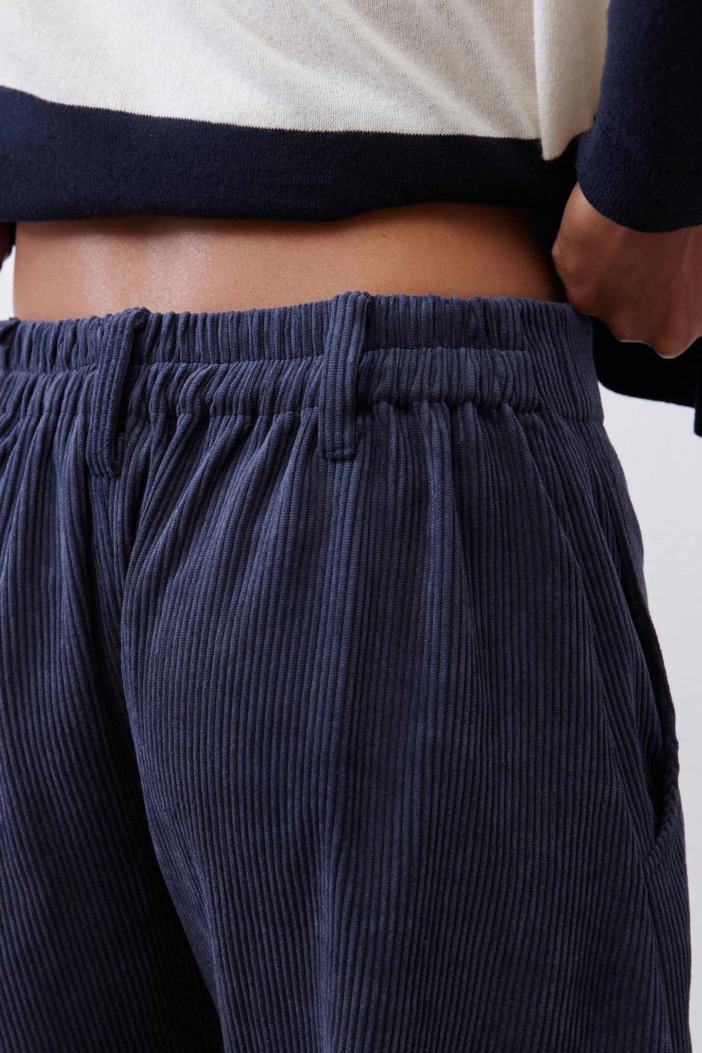 Dark navy corduroy fabric pants with elastic waistband and vertical rib texture