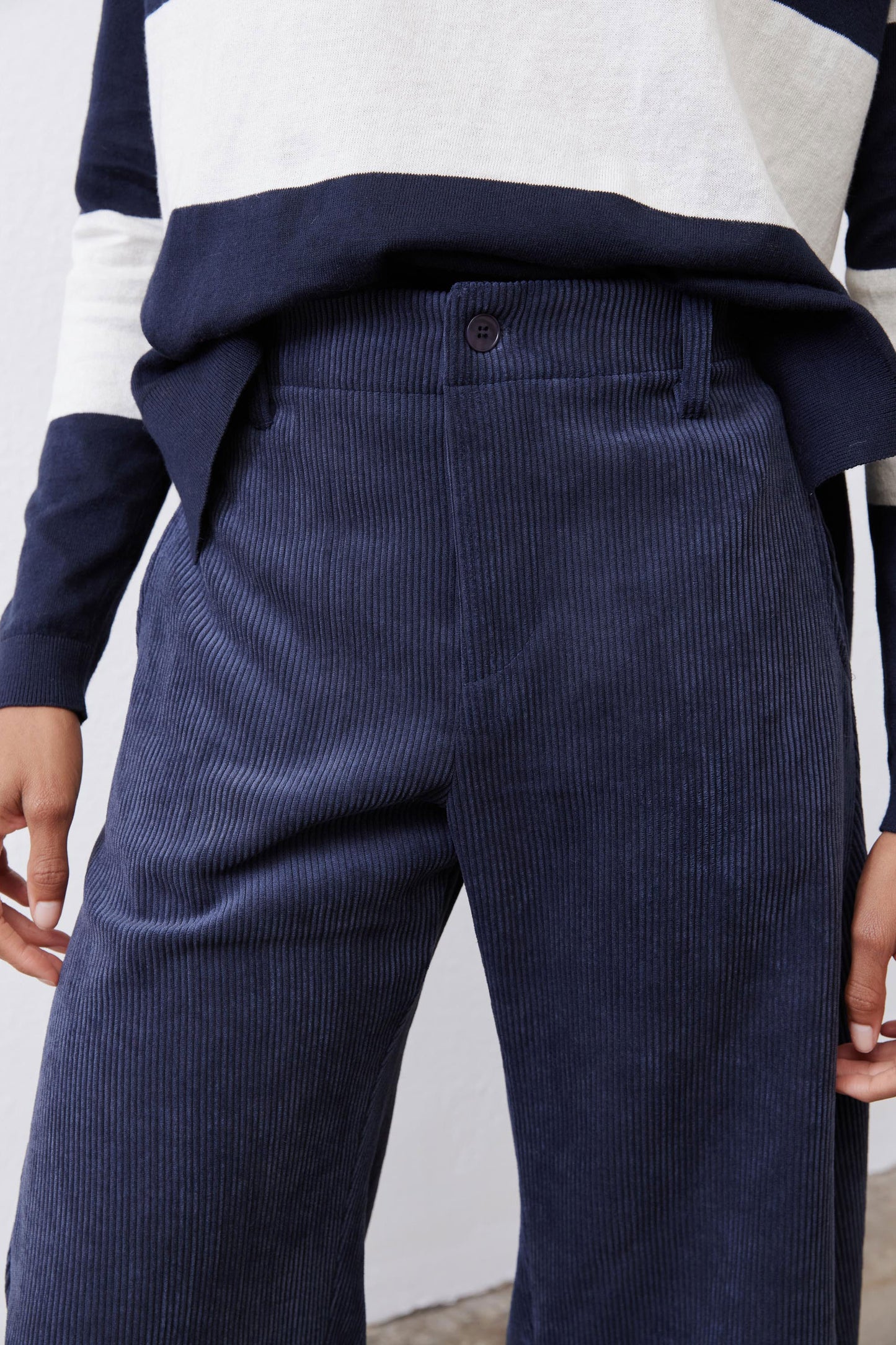 Dark navy corduroy pants with elastic waist, center front seam, and button