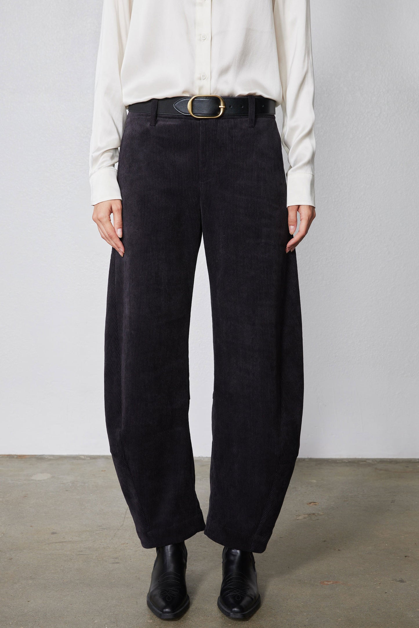 Black corduroy pants with belt loops, button fly, and wide leg opening