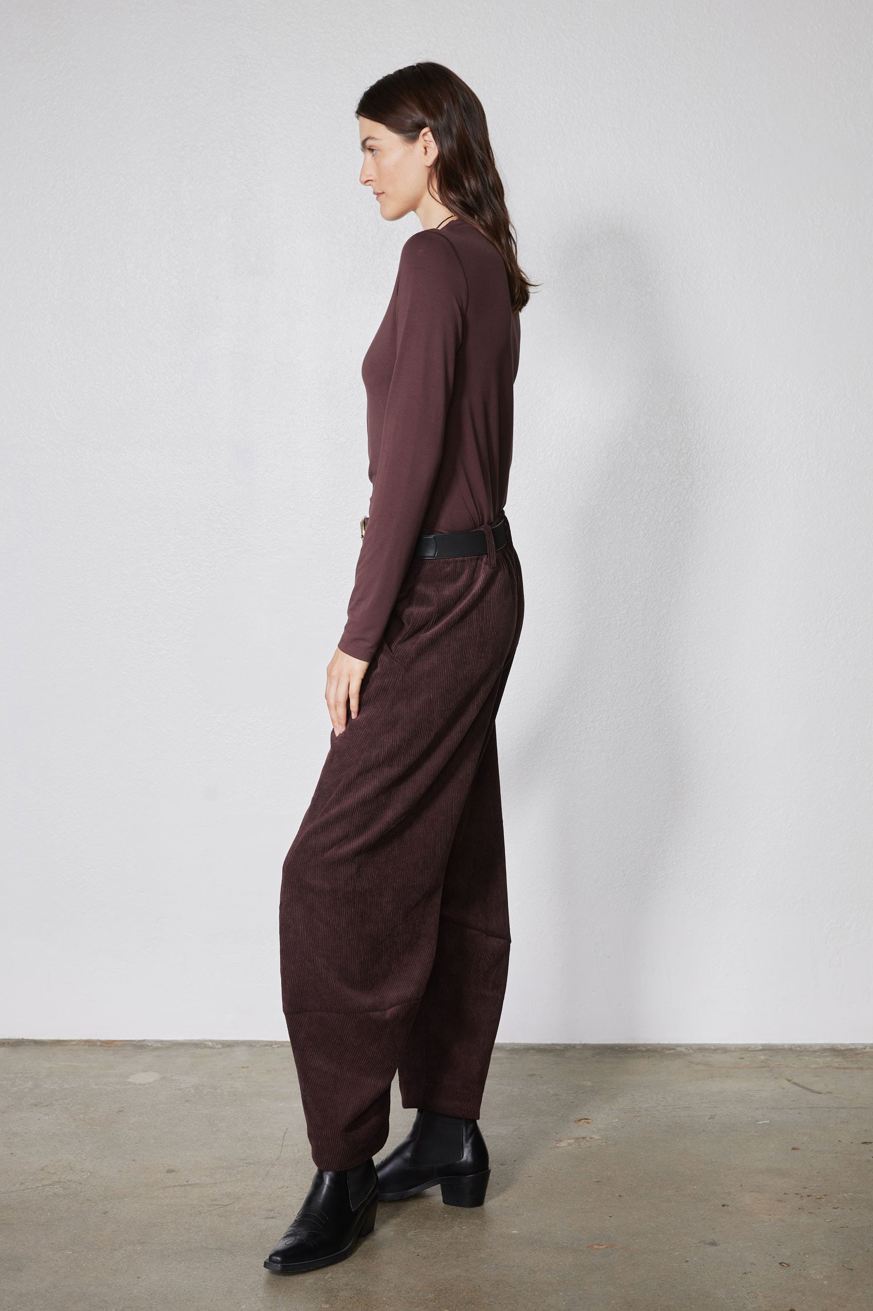 Chocolate-plum corduroy barrel pants on model, back/side view with wide leg opening
