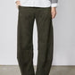 Dark olive corduroy pants with loose barrel leg silhouette and cuffed hem