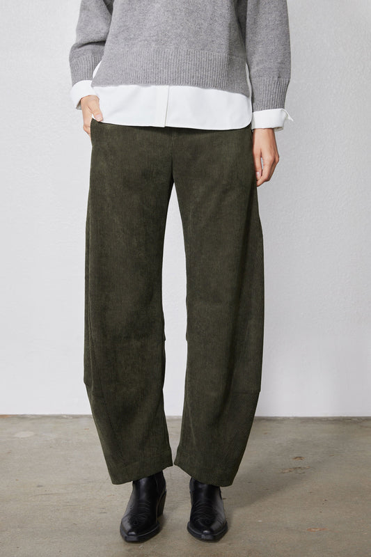Dark olive corduroy pants with loose barrel leg silhouette and cuffed hem