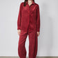 Pomegranate red corduroy barrel-leg pants with relaxed drape and ankle-length hem