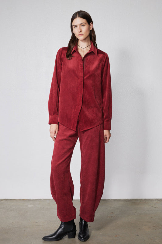 Pomegranate red corduroy barrel-leg pants with relaxed drape and ankle-length hem