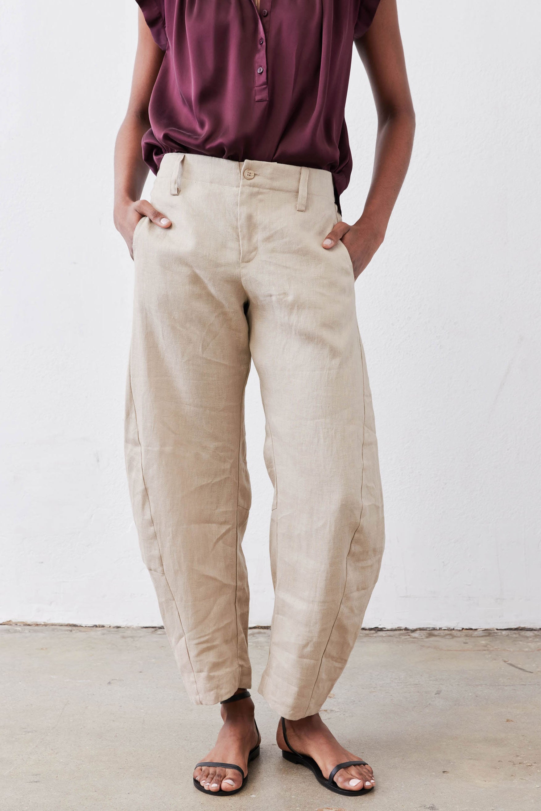 Loose linen pants in light beige with buttoned front, elastic waistband, side pockets