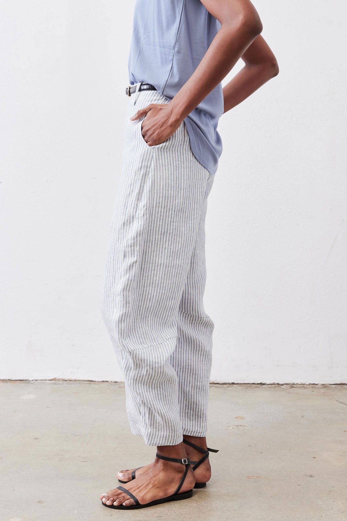 Loose linen pants with thin vertical stripes, relaxed legs and gathered cuff hems