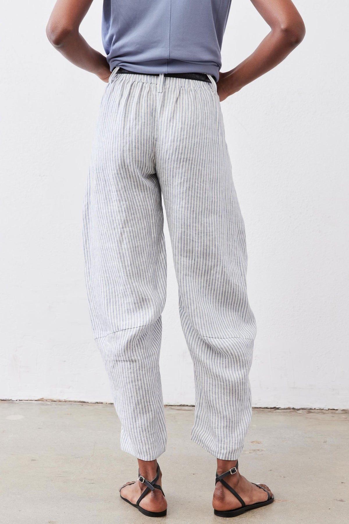 Loose linen pants with thin vertical stripes, relaxed fit and cuffed ankle length