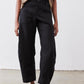 Black loose linen pants with button front and roomy tapered legs, ankle-length hem