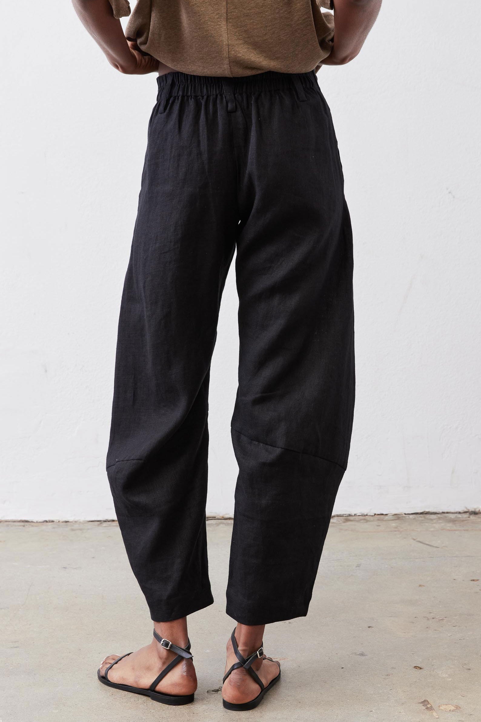 Black linen pants with elastic waistband, relaxed fit, tapered legs at ankle length