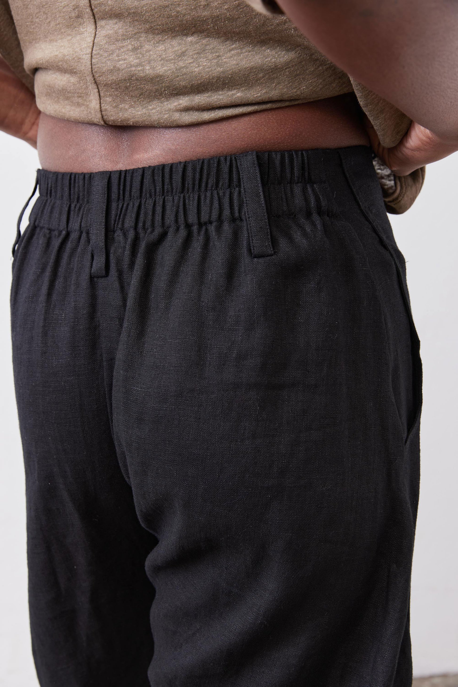 Black linen pants waistband with gathered elastic top and relaxed tapered legs