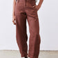 Spice brown loose linen pants with belt loops, front pockets, and tapered ankles