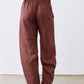 Spice brown loose linen pants with elastic waistband and cuffed ankle shape