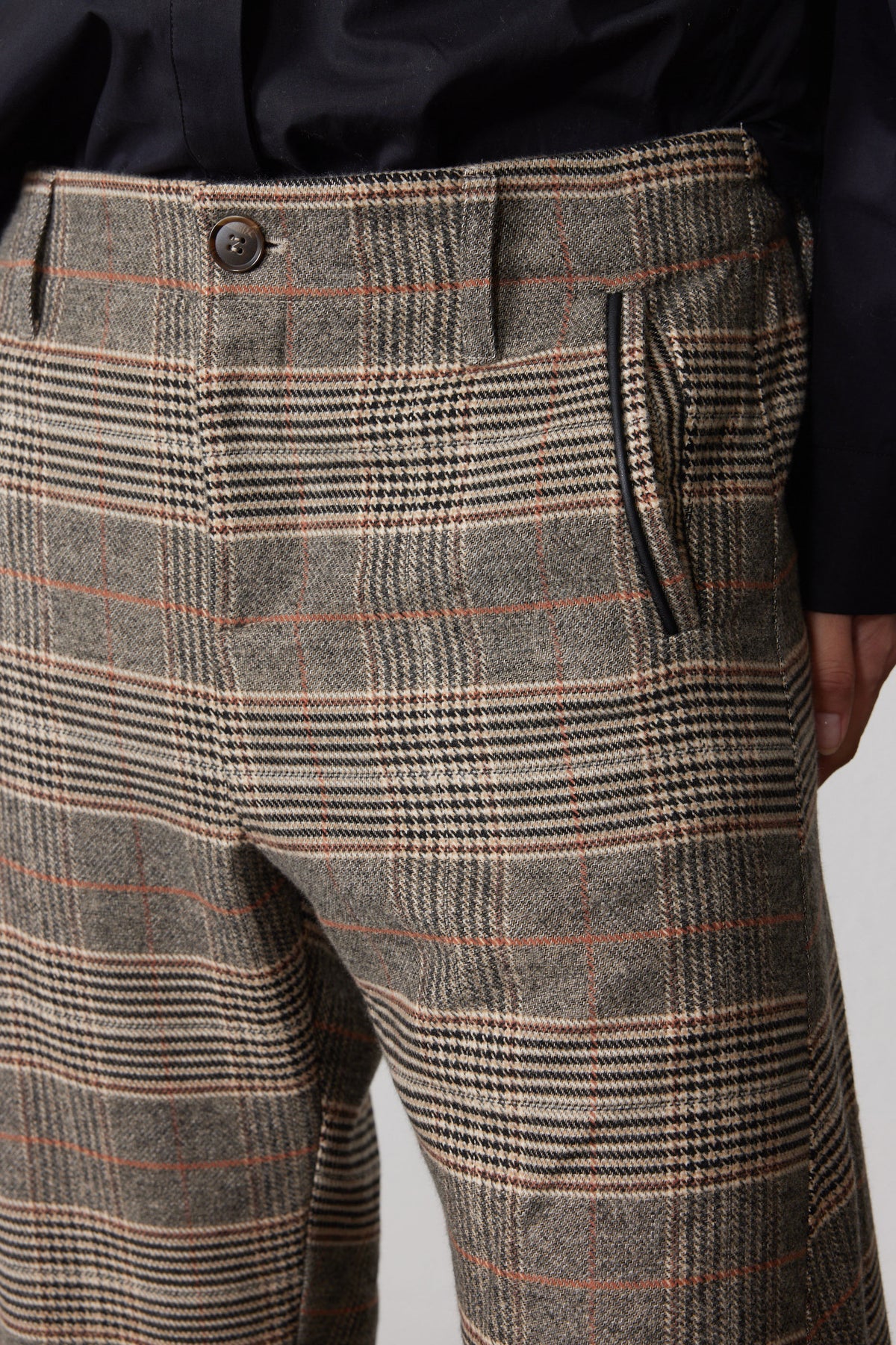 Brown plaid pants close-up: button waistband and textured woven fabric