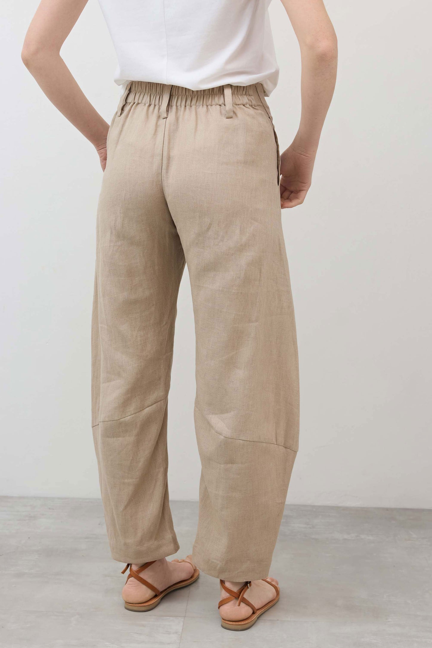 Loose linen pants in light beige, relaxed fit with elastic waist and roomy straight legs