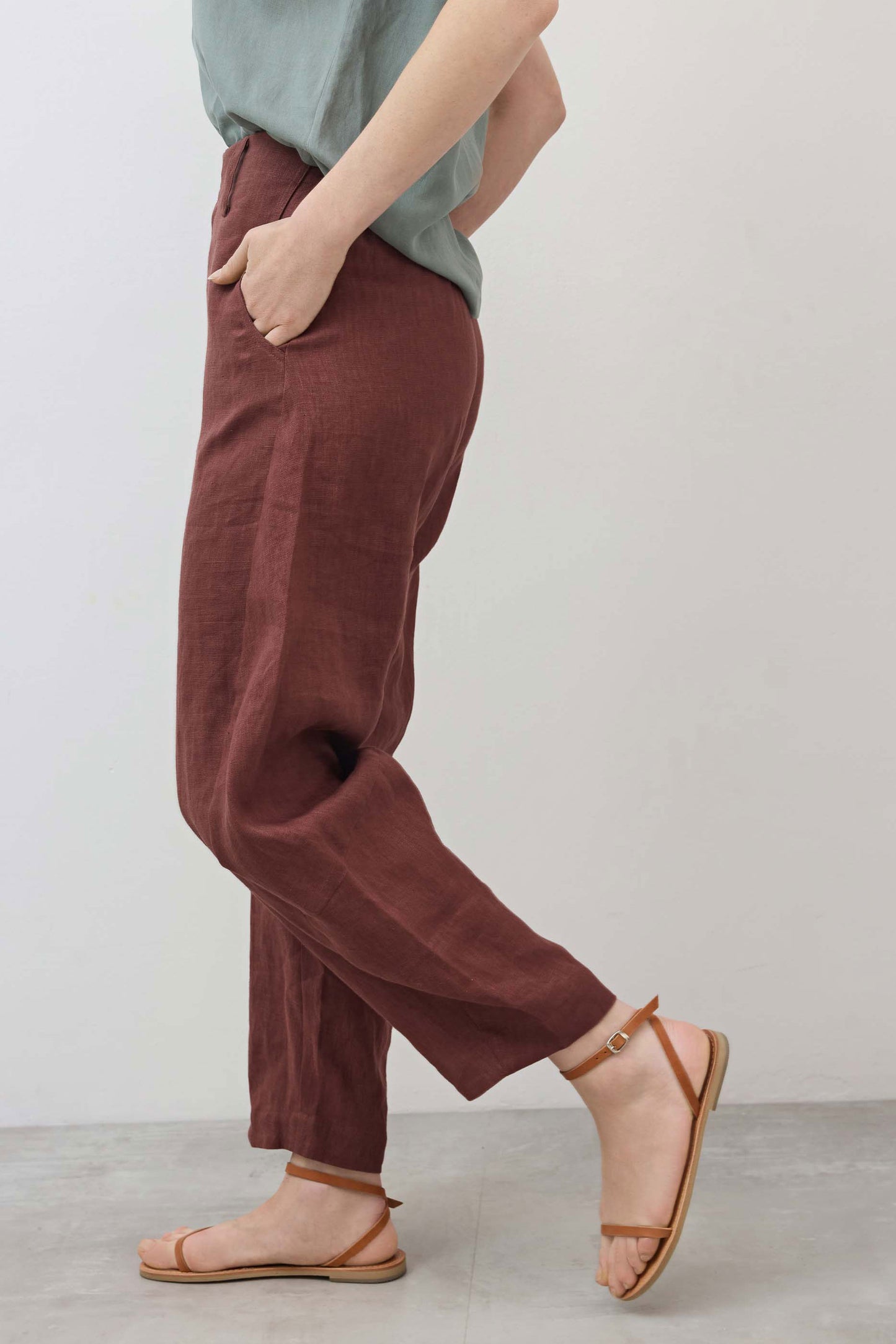 Spice brown linen pants side view with tapered ankle and slant front pocket