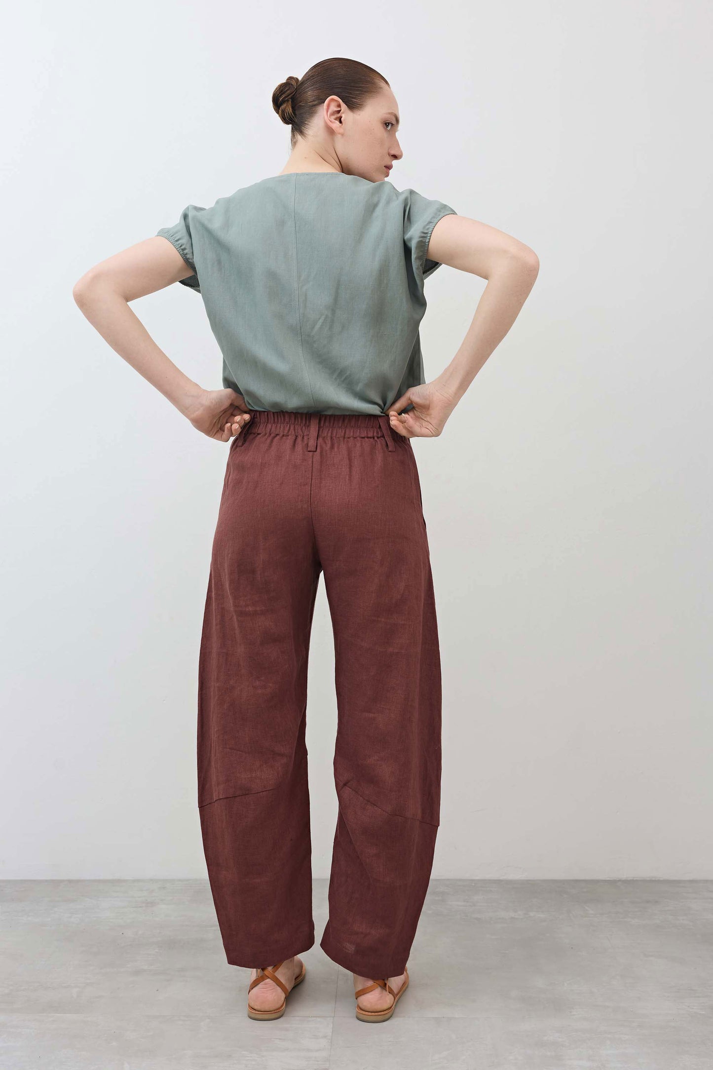 Spice brown loose linen pants back view with elastic waistband and relaxed leg